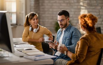 Young businessman using touchpad while having a meeting with fem